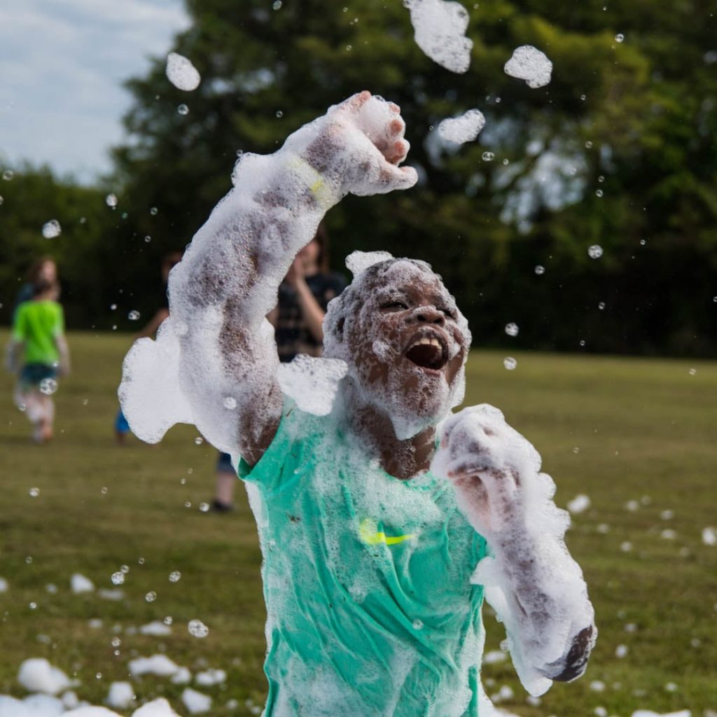 A kid jumping in foam at a birthday party